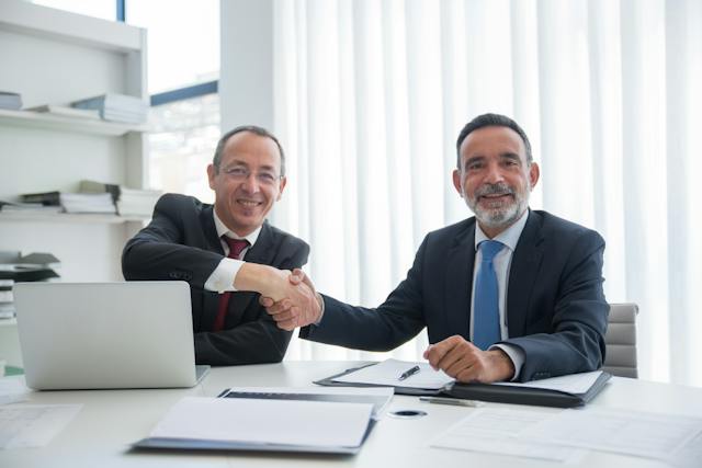 two property managers shaking hands while siting side by side